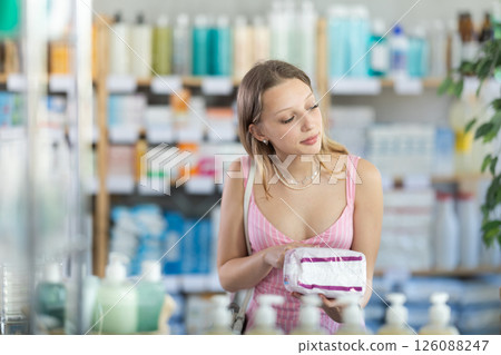 Young woman in summer dress choosing pads Young woman in summer dress choosing pads 126088247