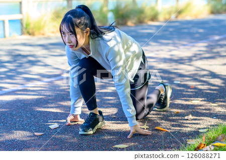 Crouching start, starting a diet, cool woman jogging along the river, trimmed up 126088271