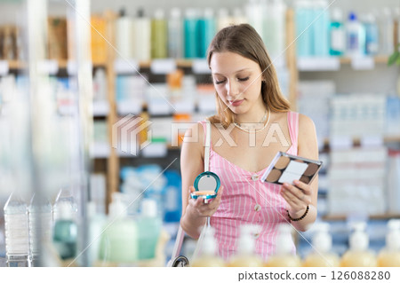 Woman in a dress choosing cosmetics in pharmacy Woman in a dress choosing cosmetics in pharmacy 126088280