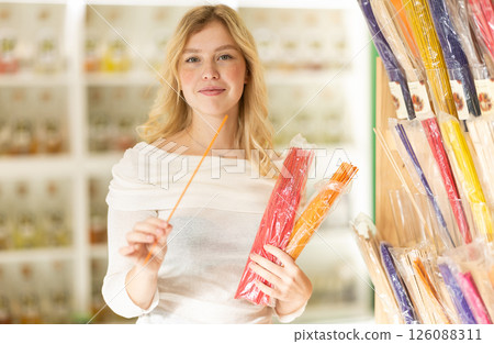 Young woman choosing incense sticks in store 126088311