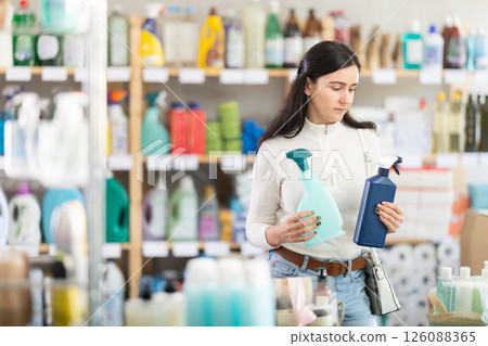 customer chooses between two sprays while standing in a supermarket customer chooses between two sprays while standing in a supermarket 126088365