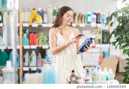 Checking expiration date of spray glass cleaner for windows - female shopper scans QR code on label of spray glass cleaner for windows using smartphone Checking expiration date of spray glass cleaner for windows - female shopper scans QR code on label of spray glass cleaner for windows using smartphone 126088384