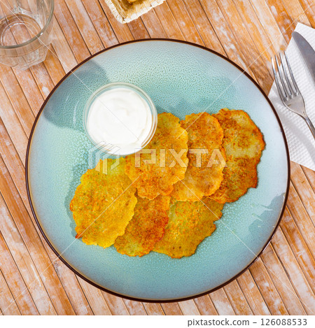 Fried grated potato pancakes with sour cream 126088533