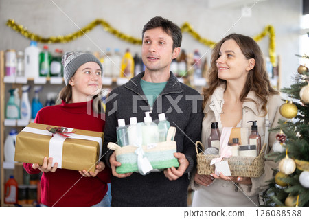 Happy family choosing toiletries gift baskets in Christmas decorated shop 126088588