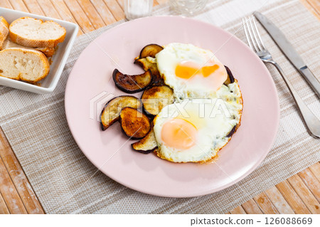 Fried sunny side up eggs with eggplant for lunch in canteen 126088669