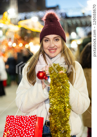 Young woman has purchased decorations for Christmas tree, tinsel and colorful balls 126088670