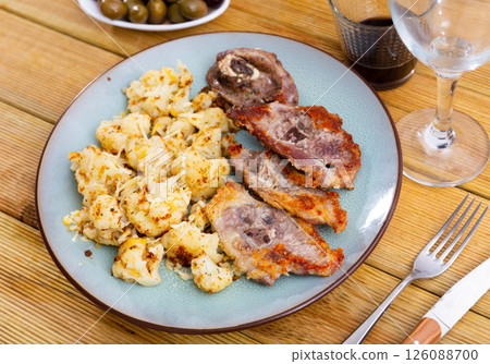Plate of fried lamb and cauliflower stew on beautifully set table 126088700
