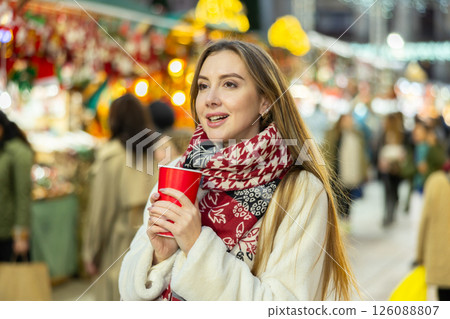 Cute woman with paper cup of hot drink walking at christmas fair 126088807