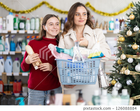 Woman and teen girl shopping for cleaning products and toiletries on New Year eve Woman and teen girl shopping for cleaning products and toiletries on New Year eve 126088884
