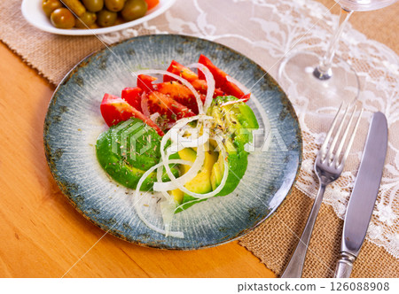 Salad from ripe avocado with tomatoes and onions 126088908
