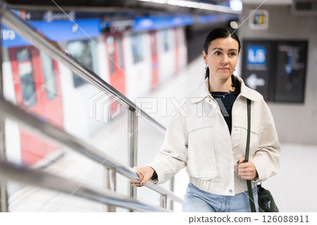 Woman metro passenger climbs stairs, enters underground public transport station Woman metro passenger climbs stairs, enters underground public transport station 126088911