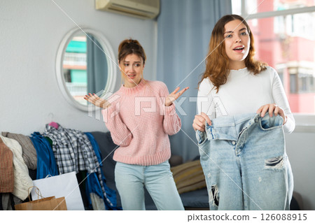 Two young women choosing clothes to wear Two young women choosing clothes to wear 126088915