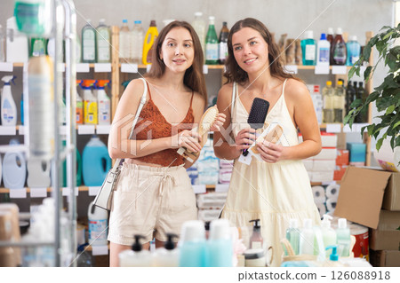 Female customers choosing hairbrushes in personal care store Female customers choosing hairbrushes in personal care store 126088918