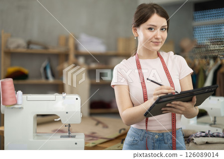 Woman dressmaker makes pattern using tablet 126089014