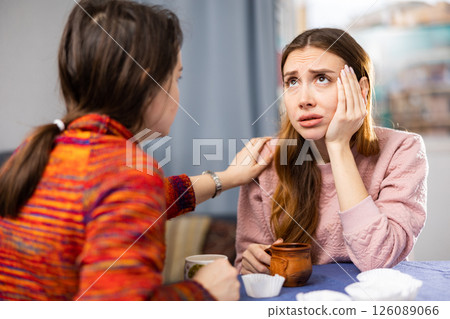 Woman comforting her depressed friend at home 126089066