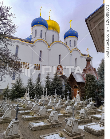 Church temple with blue and yellow domes.The graves of believers against the backdrop of a beautiful temple. Church temple with blue and yellow domes.The graves of believers against the backdrop of a beautiful temple. 126089073
