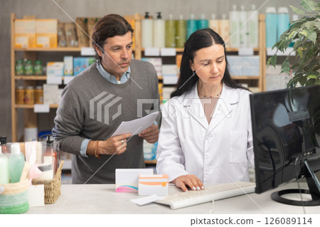 Female pharmacist checking prescription on computer Female pharmacist checking prescription on computer 126089114