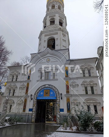 The bell tower of the man monastery with a yellow dome.Beautiful architecture of the multi-tiered bell tower with arched gates and a yellow dome. 126089141