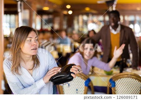 Woman leaving restaurant after stealing handbag 126089171
