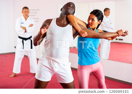 Men and woman training self-protection martial arts in gym 126089181