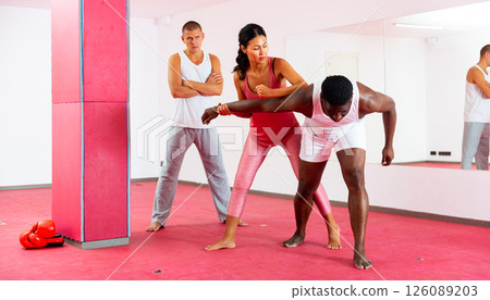 Self defense trainer teaches asian woman strength techniques in sport gym 126089203