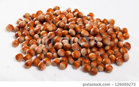 Heap of raw hazelnuts on white Heap of raw hazelnuts on white 126089273