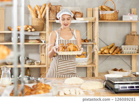 Young female baker with basket of croissants Young female baker with basket of croissants 126089281