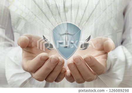 Hands holding a shield with scales of justice 126089298