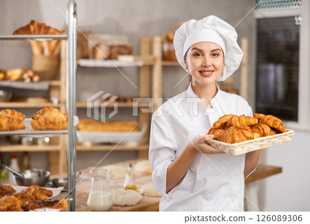 Young female baker with basket of croissants Young female baker with basket of croissants 126089306