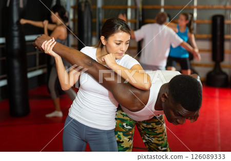 Women and men exercising during self-defence training Women and men exercising during self-defence training 126089333