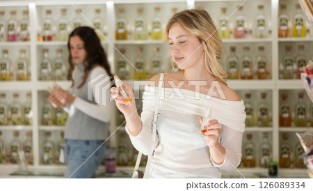 Young woman choosing perfume in store Young woman choosing perfume in store 126089334