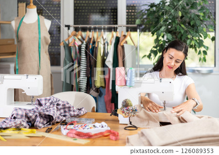 Woman tailor sews clothes in sewing machine 126089353