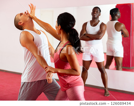 Active woman with professional trainer are training captures on self-defense course Active woman with professional trainer are training captures on self-defense course 126089434