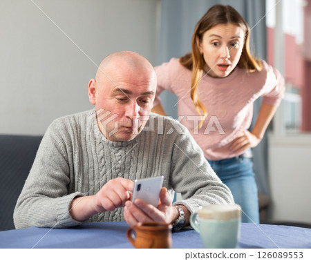 Man is texting on a mobile phone, while woman is outraged 126089553