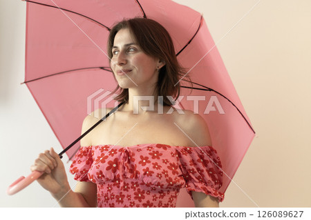 woman in a pink blouse with open shoulders under a pink umbrella woman in a pink blouse with open shoulders under a pink umbrella 126089627