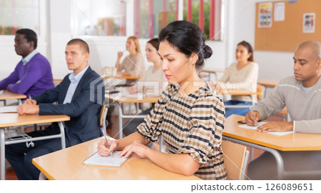 Focused japanese woman listening lecture at adult education class Focused japanese woman listening lecture at adult education class 126089651