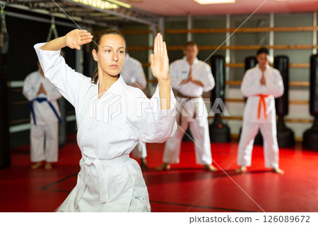 Woman in kimono showing fight stance during karate training 126089672