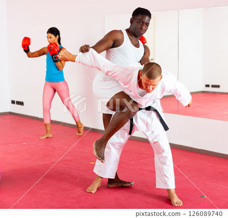 Two men exrcising self defence moves and woman boxing 126089740