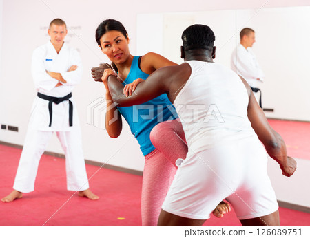 Woman training together with african american man in self defense lessons 126089751