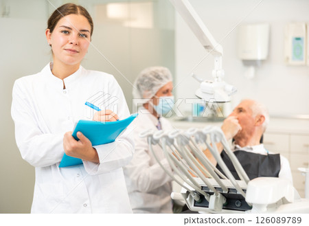Young woman nurse taking notes in dental office Young woman nurse taking notes in dental office 126089789