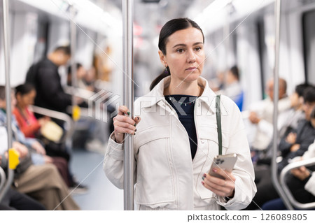 Woman using smartphone while traveling in subway car 126089805