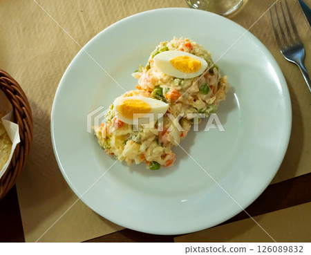 Olivier salad of potatoes, carrots, pickled cucumbers, eggs and green peas 126089832