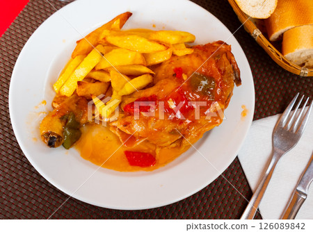 Stewed chicken leg quarter with vegetable garnish of fries 126089842