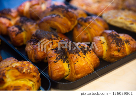 Closeup of various delicious sweet croissants presented on bakery showcase Closeup of various delicious sweet croissants presented on bakery showcase 126089861