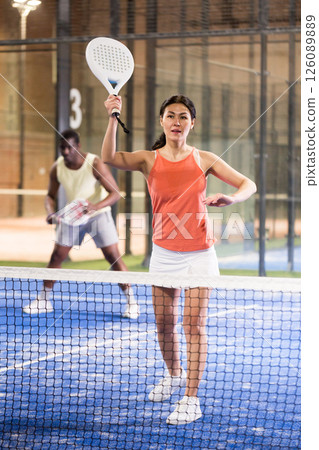 Young asian woman playing padel on a hard court Young asian woman playing padel on a hard court 126089889