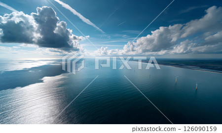 Towering wind turbines over the ocean, the seas harness the gentle sea breeze over the vast waters, demonstrating sustainable energy in action. Going Green 126090159