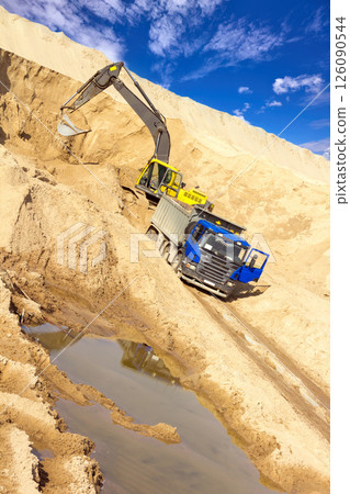Excavator Loading Sand into Dump Truck at Quarry Site Excavator Loading Sand into Dump Truck at Quarry Site 126090544