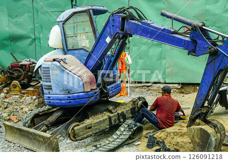 Broken mini excavator on the street, at a work site, on-site repair, Ho Chi Minh City, Vietnam Broken mini excavator on the street, at a work site, on-site repair, Ho Chi Minh City, Vietnam 126091218