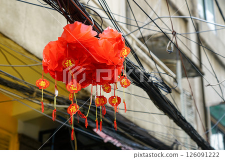 Traditional Chinese red paper lantern with inscriptions blessing hanging in tangle of wires Traditional Chinese red paper lantern with inscriptions blessing hanging in tangle of wires 126091222