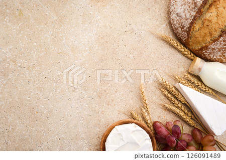Jewish holiday Shavuot concept. Grains, milk and cheese on travertini stone background Jewish holiday Shavuot concept. Grains, milk and cheese on travertini stone background 126091489